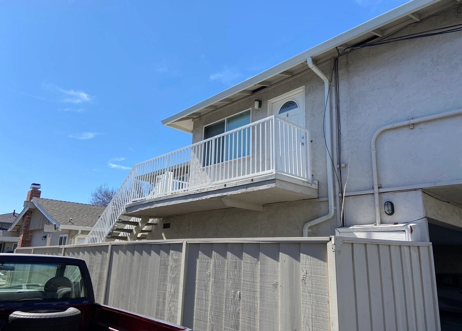 A white balcony railing installed on a two-story home, an ATR Welding installation